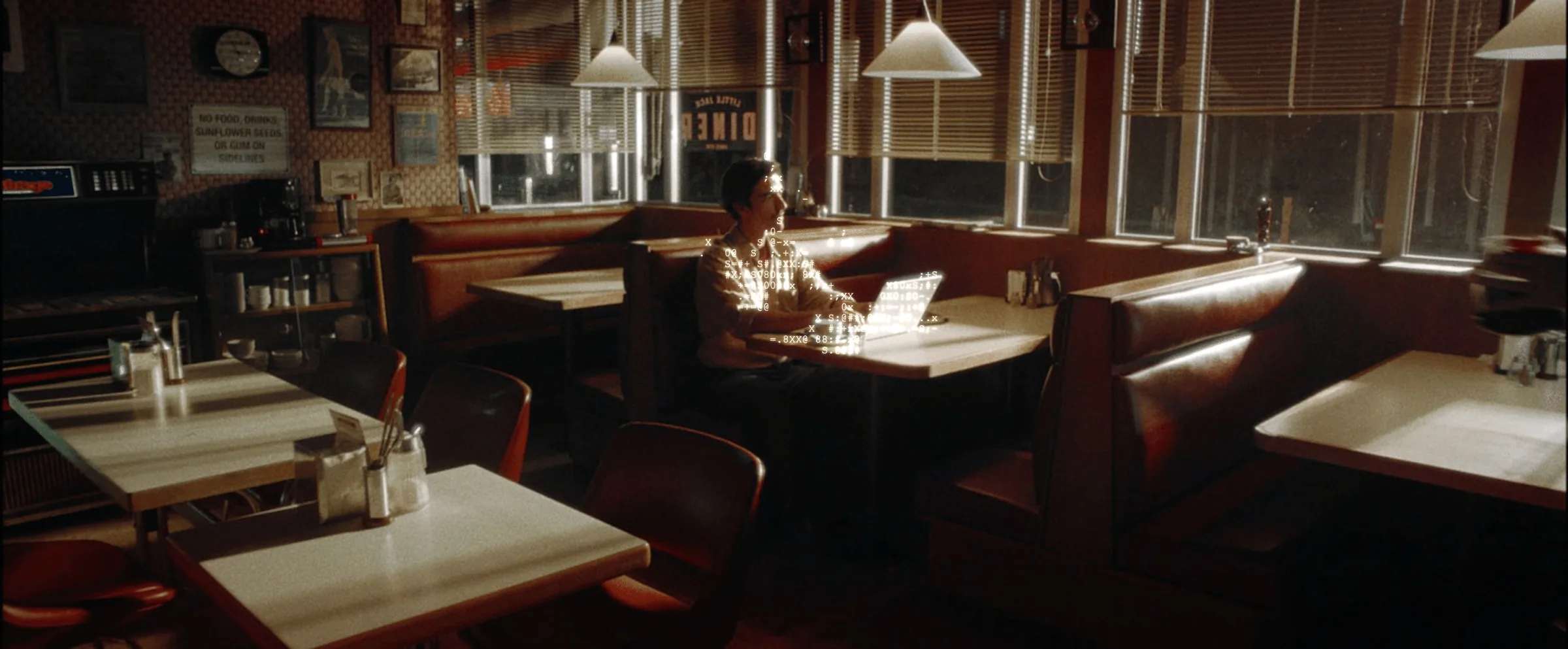 A restaurant manager sits alone in an empty diner