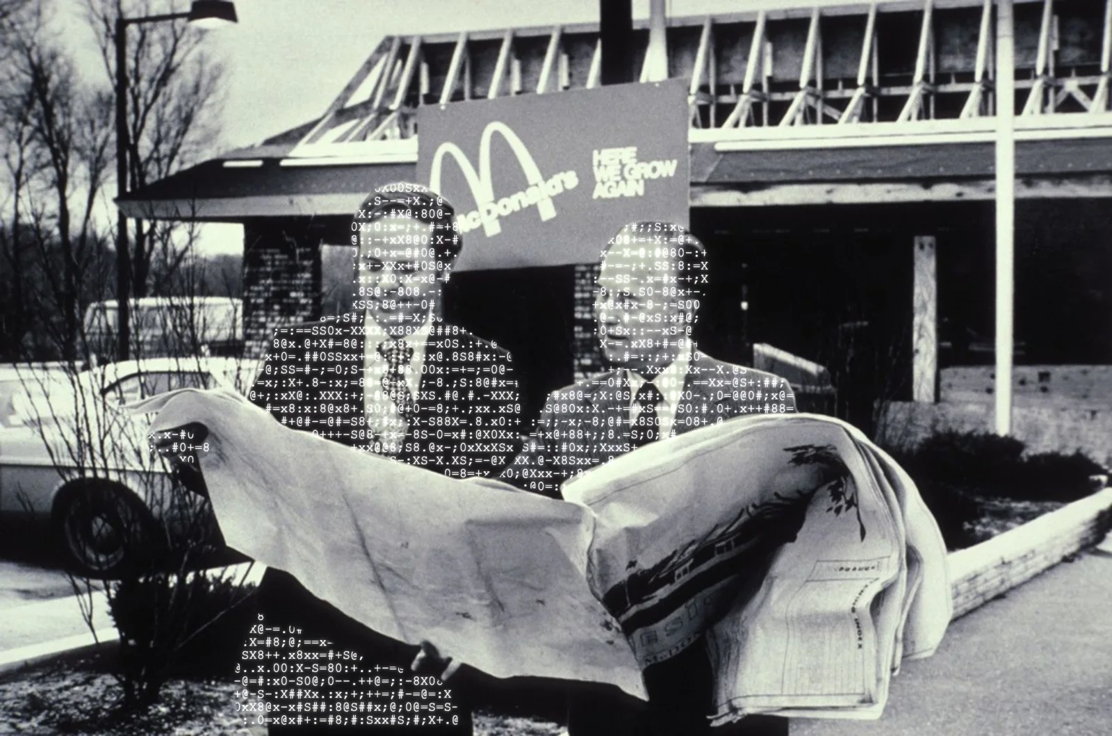 Two men standing outside a McDonald's and holding a paper